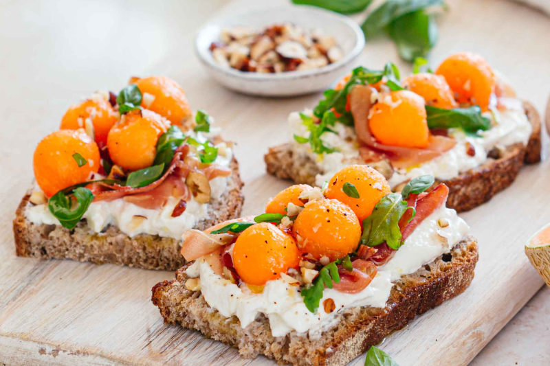 Tartines aux melon, burrata, jambon cru et noisettes concassées