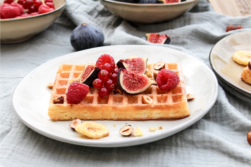 Gaufres aux figues fraîches, chips de bananes, fruits rouges et noisettes toastées