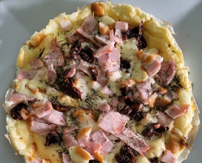 Une pizza factice de blancs d'œuf, jambon blanc et scamorza